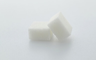 Two sugar cubes on white background