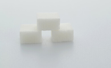 Three sugar cubes on white background