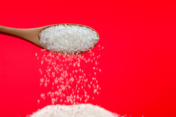 Sugar crystals falling out of wooden spoon