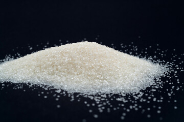 Pile of white sugar crystals on black background