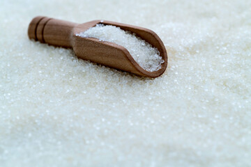 Fototapeta na wymiar Granulated sugar on wooden scoop