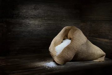 Fotobehang Krokus Hessian bag overflowing long grain White Rice rustic wooden box spotlight mood lighting copy space  © Tony Zuvela 