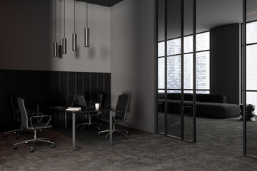 Grey office interior with workplace and laptop, relaxing zone and window