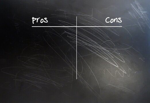 Black chalkboard with text handwritten PROS and CONS,concept of  making a list to compare or weigh all good (advantages) and bad (disadvantages) sides before making decision , consider carefully