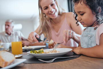 Obraz na płótnie Canvas Family, mother and cutting food for girl while having lunch at dinner table in home. Love, foster care and happy mom helping child with eating, smiling and enjoying a delicious meal together in house