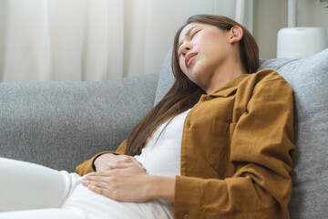 Flatulence asian young woman hand in stomach ache, suffer from food poisoning, abdominal pain and...