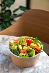 Avocado and fresh tomatoes salad in bowl on gray stone background top view. Concept Food For Parties. Fast Food.