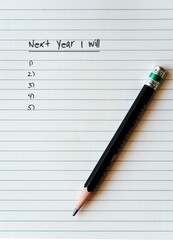 A pencil on a white blank empty note paper note with text written NEXT YEAR I WILL and blank lists...