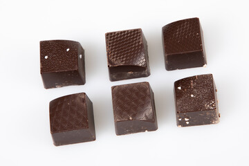 square fine dark milk artisanal chocolate pralines candies in flat top view white background