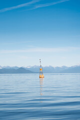 Buoy in the open sea with mountains in the distance. Kamchatka