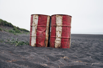 Two red rustick barrels on black sand beach. Kamchatka