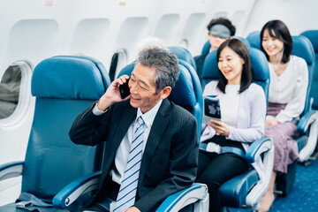飛行機で出張に出かけるミドルのビジネスマン
