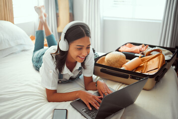 Computer travel and woman packing for a vacation with headphones typing a holiday blog. Adventure,...