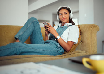 Relax, phone and woman on a sofa with music, radio and online entertainment in a living room, happy...