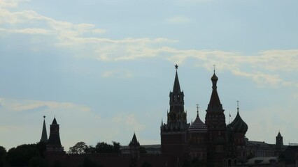 Domes of the Moscow Kremlin under a blue sky with floating clouds.