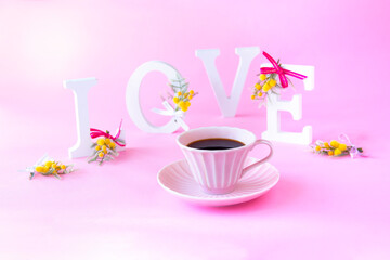 LOVEのアルファベットの文字と小さなミモザの花束とコーヒー-----バレンタイン・イメージ