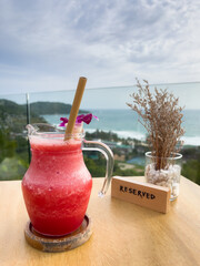 Fresh watermelon juice on restaurant table with great views of Kata Noi beach in Phuket, Thailand. Summer vacation leisure moment, travel destination concepts