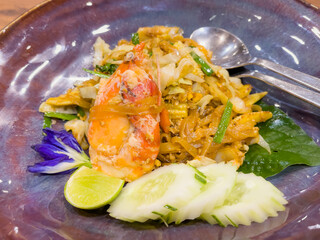 Pad thai with king prawns, lemon and cucumber slices. Traditional Thai food plate