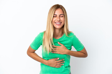 Blonde Uruguayan girl isolated on white background smiling a lot