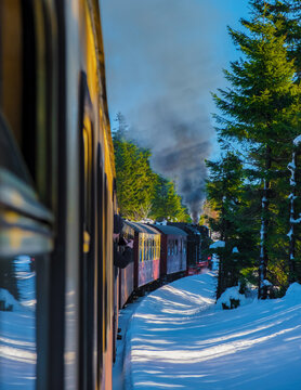 Steam train during winter in the snow in the Harz national park Germany on a sunny day