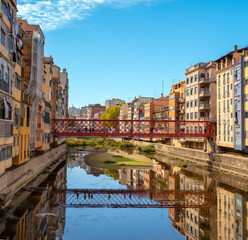 Fototapeta na wymiar Girona, colored houses and red touristic bridge in Spain