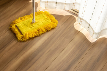 フローリングの床と黄色いモップ。掃除のイメージ