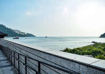 Obraz premium A view from the shore. A calm seascape under the light blue sky.