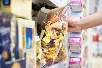 Woman with package pasta in shop