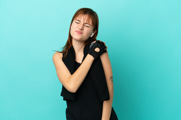 Redhead sport girl isolated on blue background suffering from pain in shoulder for having made an effort