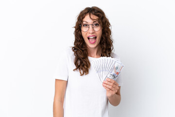 Young woman with curly hair taking a lot of money isolated background on white background with surprise facial expression