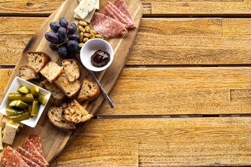 overhead view of charcuterie board on a wooden table with copy space