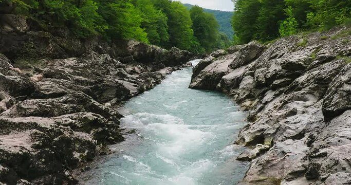 Aerial view of Mountain river and road. Flying over a mountain gorge. Slow motion 120 fps.