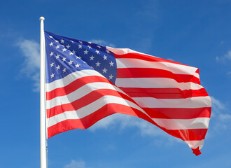 american flag with stars and stripes flying in the blue sky