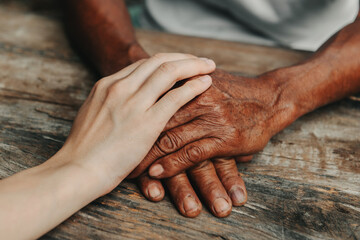 Fototapeta premium Young man holding senior woman hands, closeup