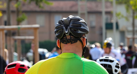 cyclist with helmet of protection and other cyclists before the cycling race - obrazy, fototapety, plakaty