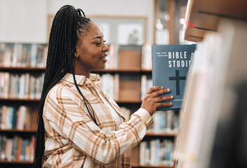 Religion book, education and black woman in a library for research, studying God and knowledge on...