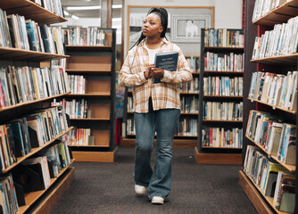 Search, university or black woman in a library for books, educational knowledge or research on a...