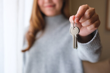 Blurred of a woman holding and showing the keys for real estate concept