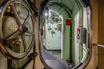 Inside a submarine with a metal door and different technical facilities