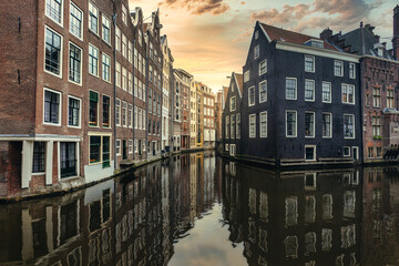 Naklejka premium A view of city buildings in water reflection under the bright sky in Amsterdam