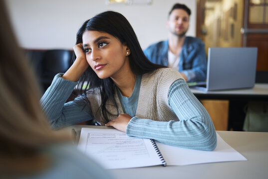 Student woman, classroom and thinking for education, college or learning for idea development. University, class lecture or female college student with daydream, bored and attention at desk in London
