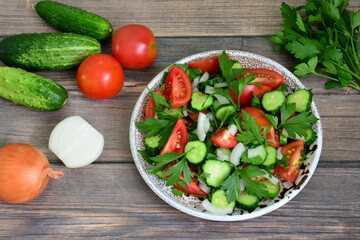 mixed vegetable salad with tomato, cucumber, oinon and parsley isolated, macro