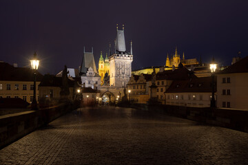 Fototapeta na wymiar Charles bridge at night. The Bridge and the towers in gothic style. Charles Bridge are the symbols of Czech capital, built in medieval times