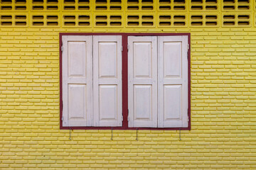 White wooden window on yellow brick wall for background.