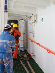 A man in ship's fire outfit on board a vessel opening door