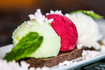 Balls of ice cream and mint leaf on plate. Close up
