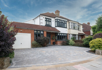 Typical semi-detached house in South East England, UK with anthracite grey windows and block paving...