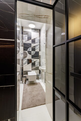 Modern room finished with black marble near the entrance to the bath area and bathroom