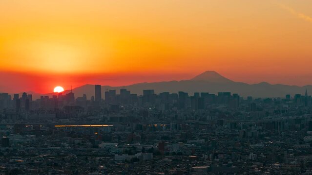 Timelapse video of Tokyo skyscrapers with Mt. Fuji silhouette from dusk to night.