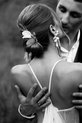 Black and white photo of a wedding couple hugging in nature